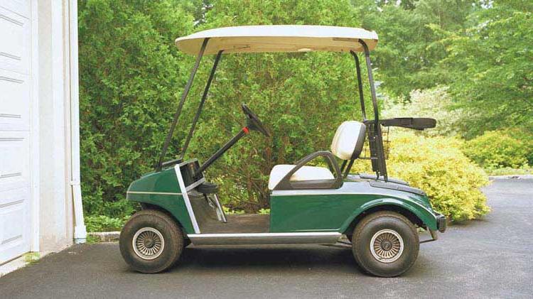 一辆高尔夫球车停在车道上.